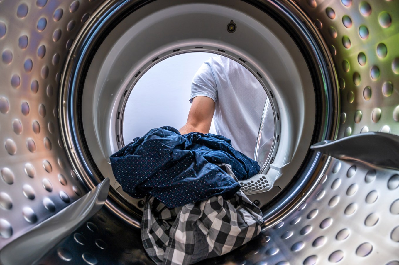 A washing machine being loaded; timing energy use could help with electric bills.