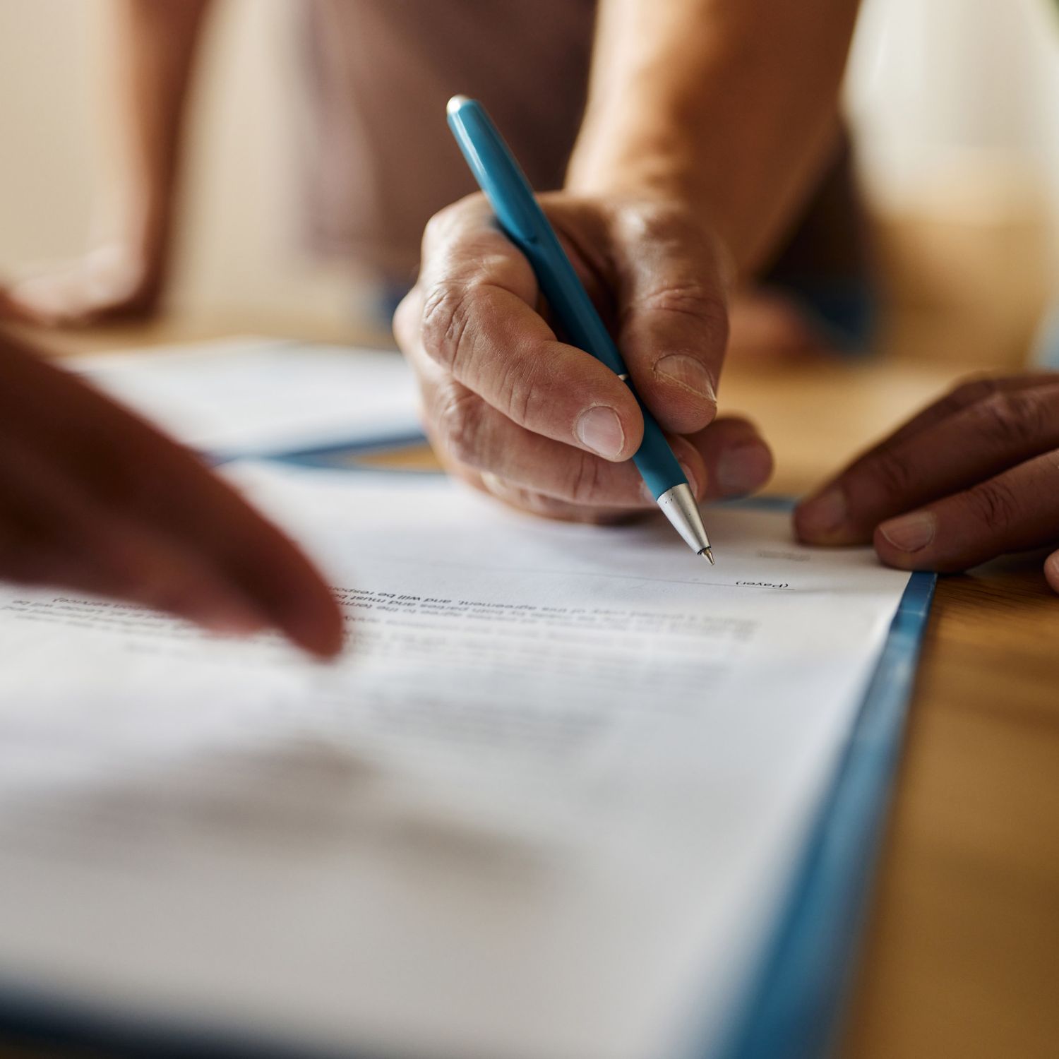 Close up of unrecognizable person signing a contract for private mortgage insurance in the office.