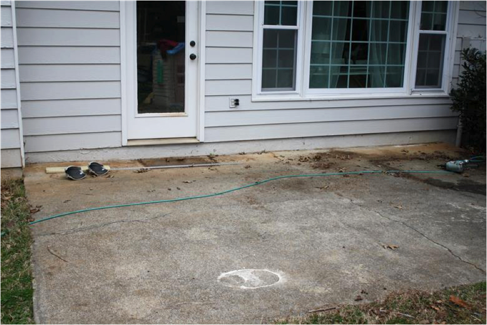 A cracked concrete slab outside of a white door