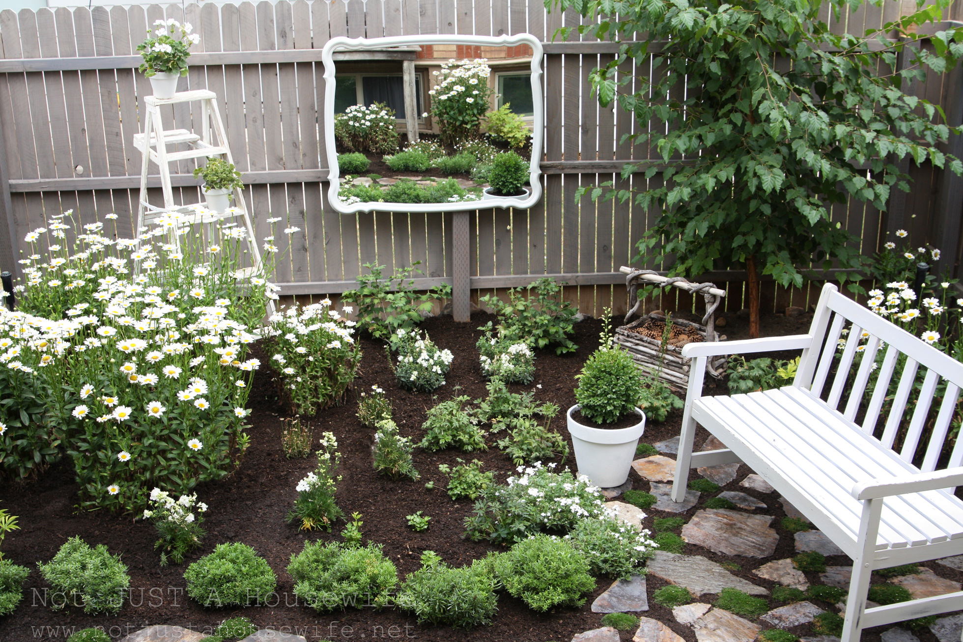 A mirror on a fence in an outdoor space with patio furniture