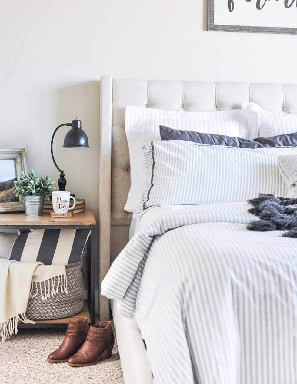 Bed with blue and white striped comforter & padded bed frame