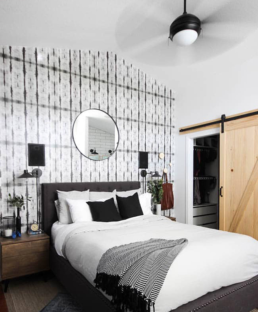 Black and white bedroom with natural accents and ceiling fan