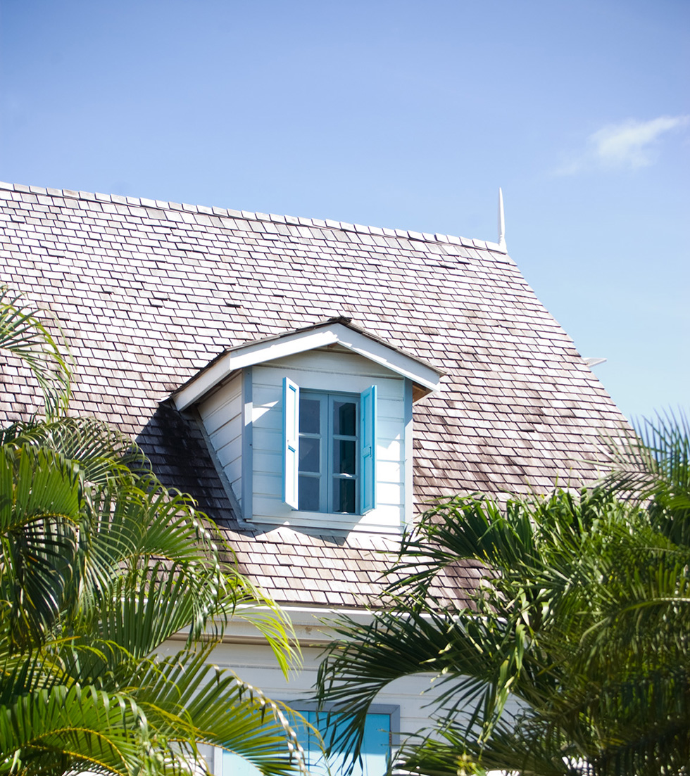 Roof on a white house against a blue sky in a tropical area