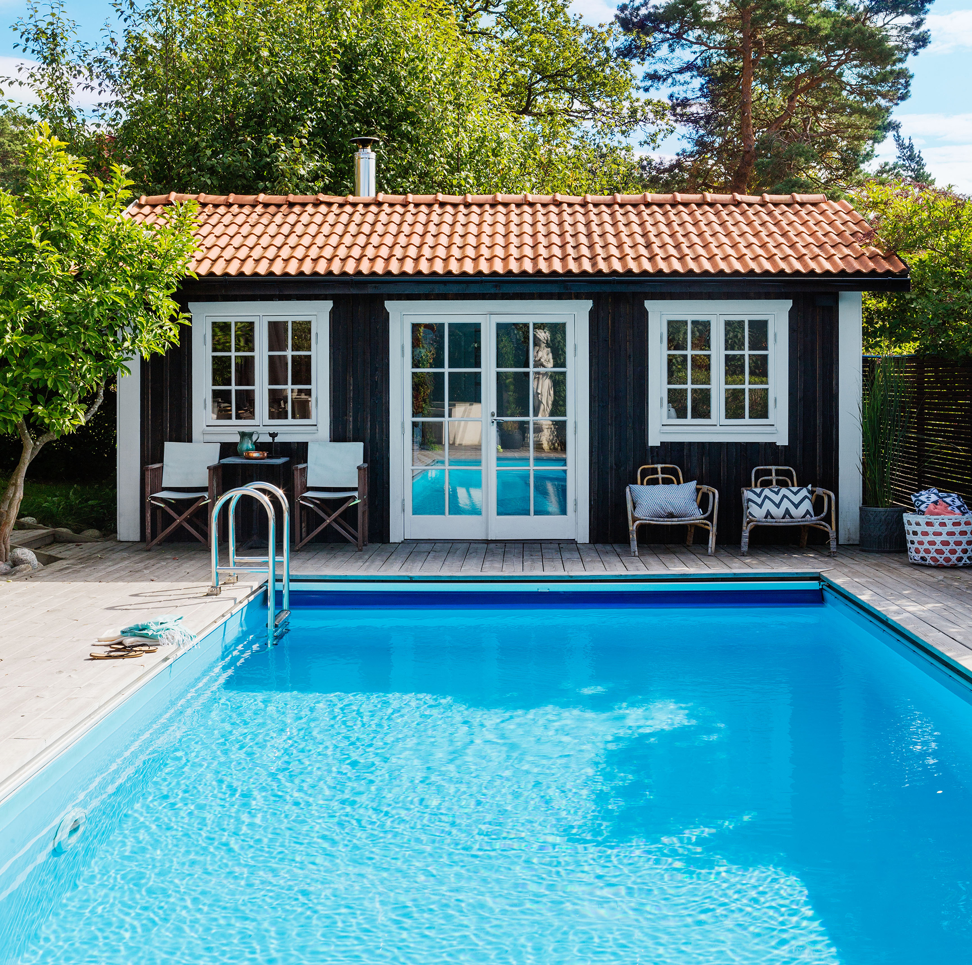 Inviting in-ground swimming pool with dark blue pool house