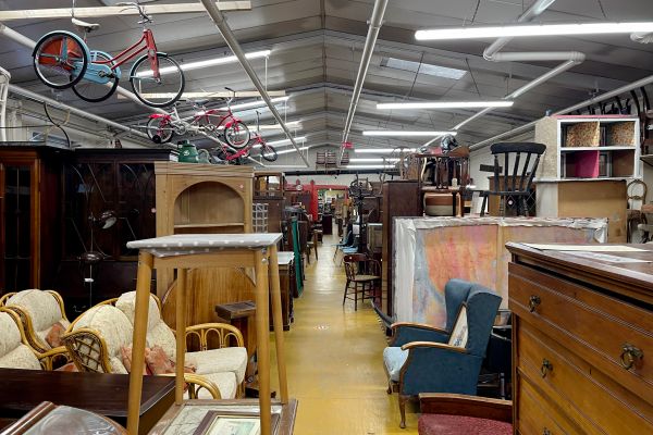 Overwhelming view of furniture at a thrift store.
