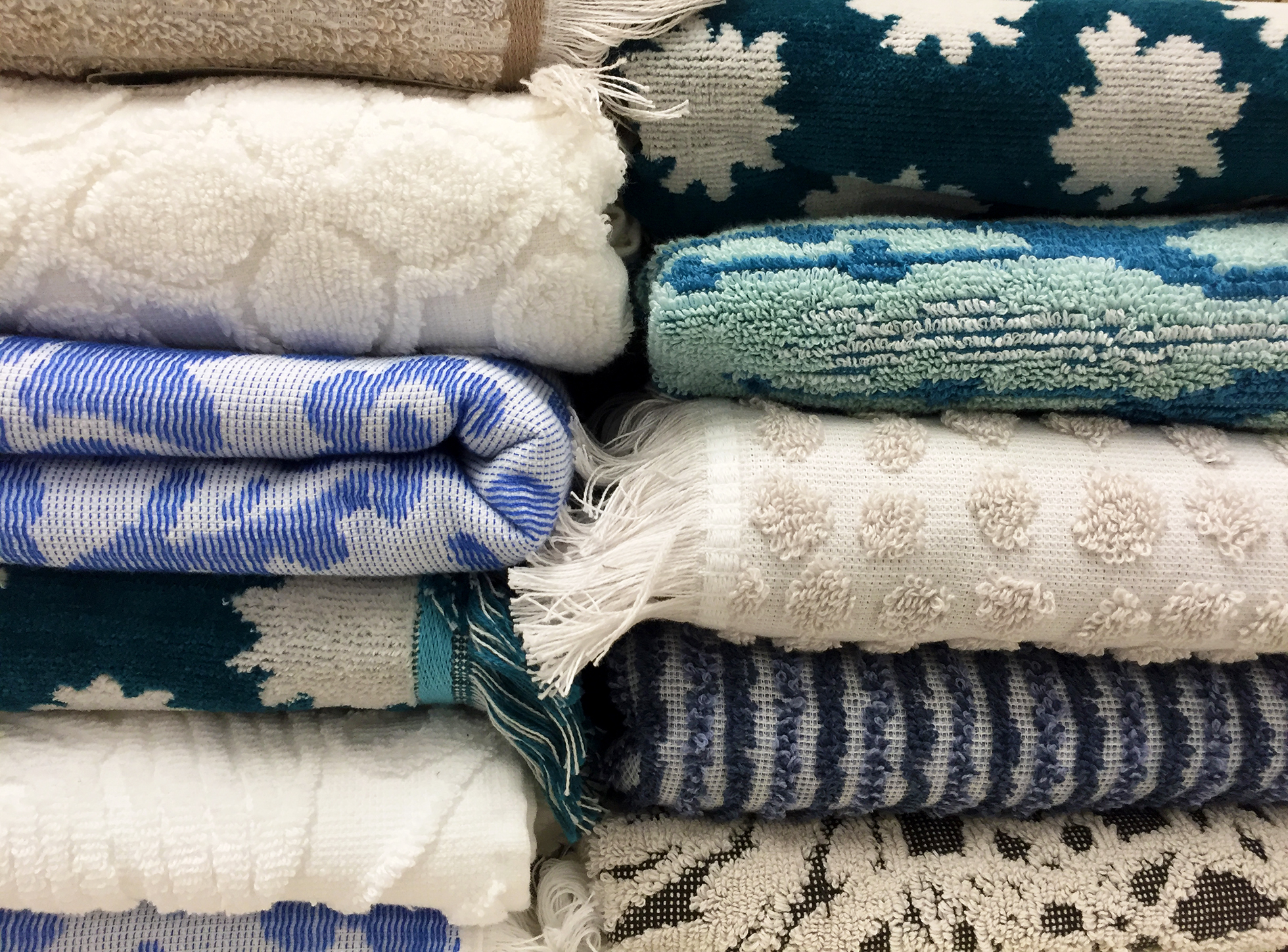 Towels of assorted textures and colors stacked neatly
