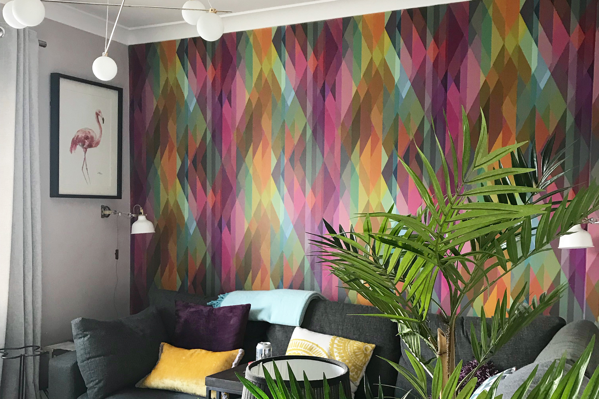 A wall in a living room covered in multi-colored wallpaper