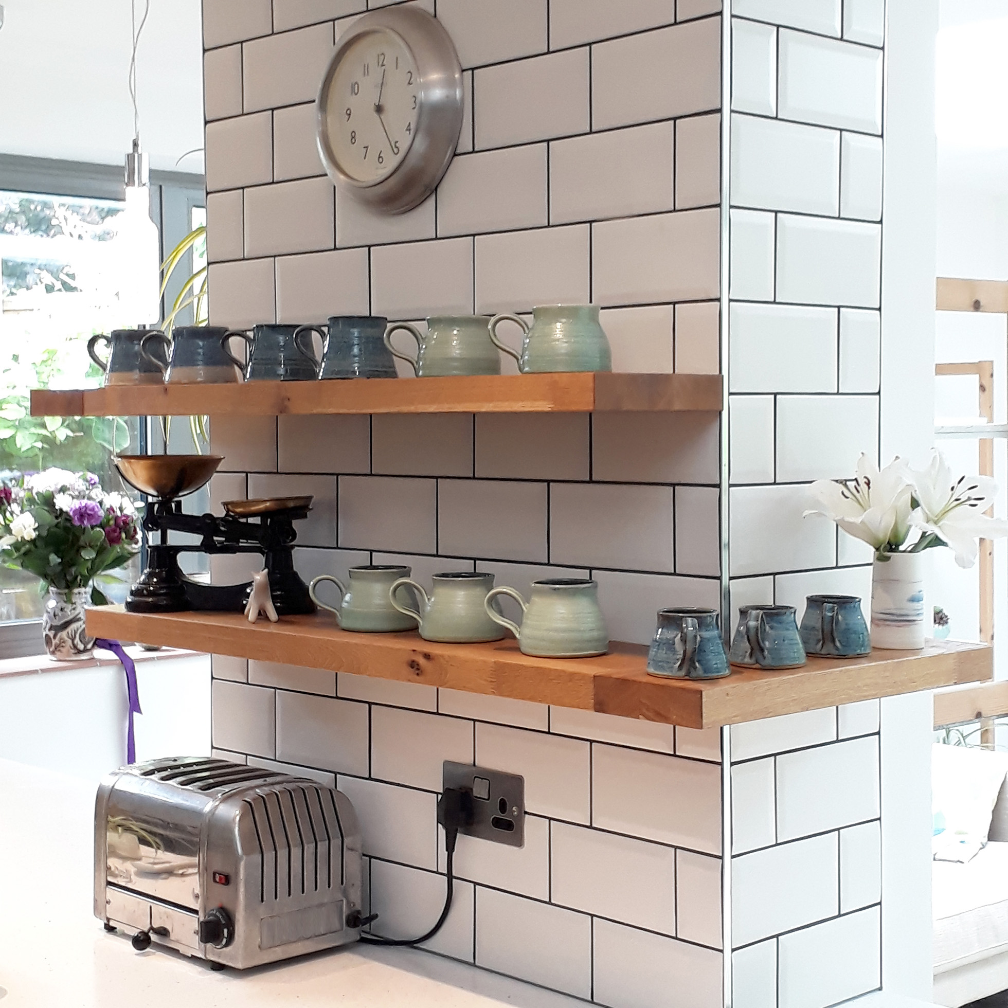 Assortment of clay pots laid out on shelves in kitchen