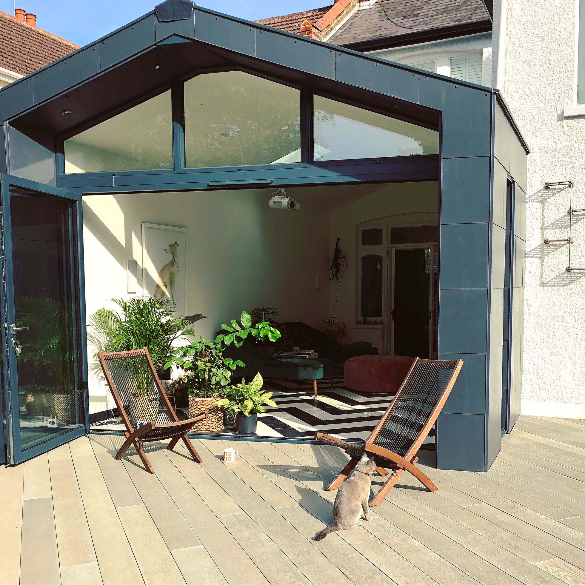 Cat on a composite deck with chairs and view of living room