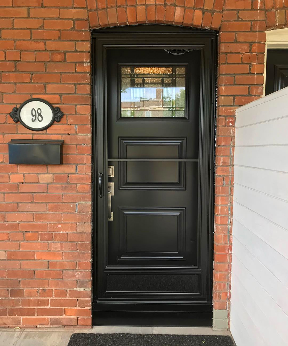 Black fiberglass front door on red brick house