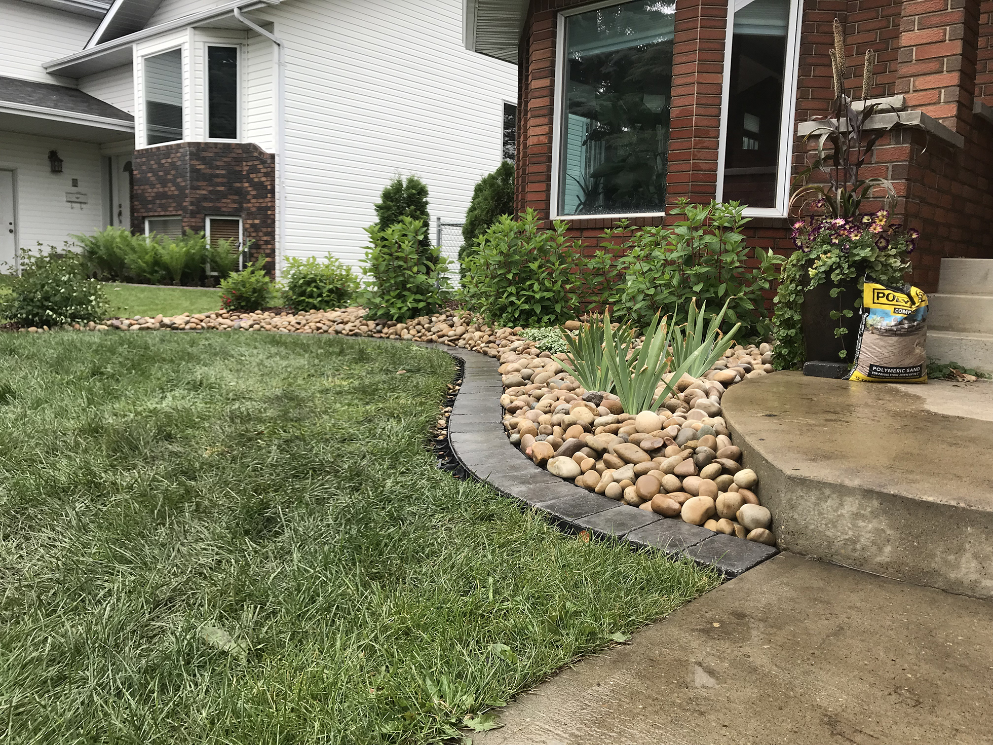 Rock edging outside red brick house | Curb Appeal Ideas