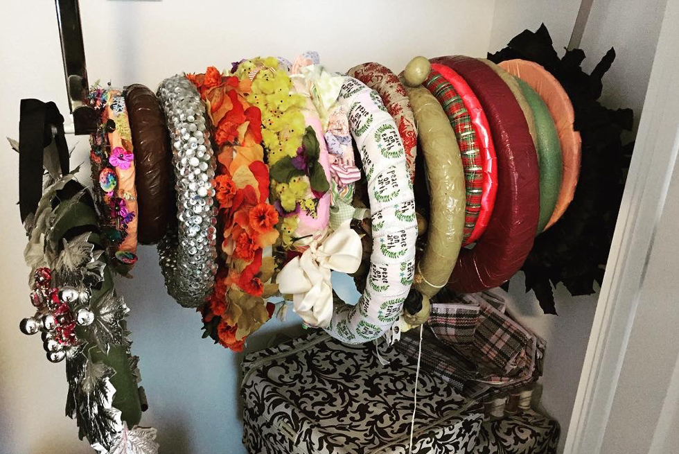 Colorful DIY wreaths hanging on a bar in a closet