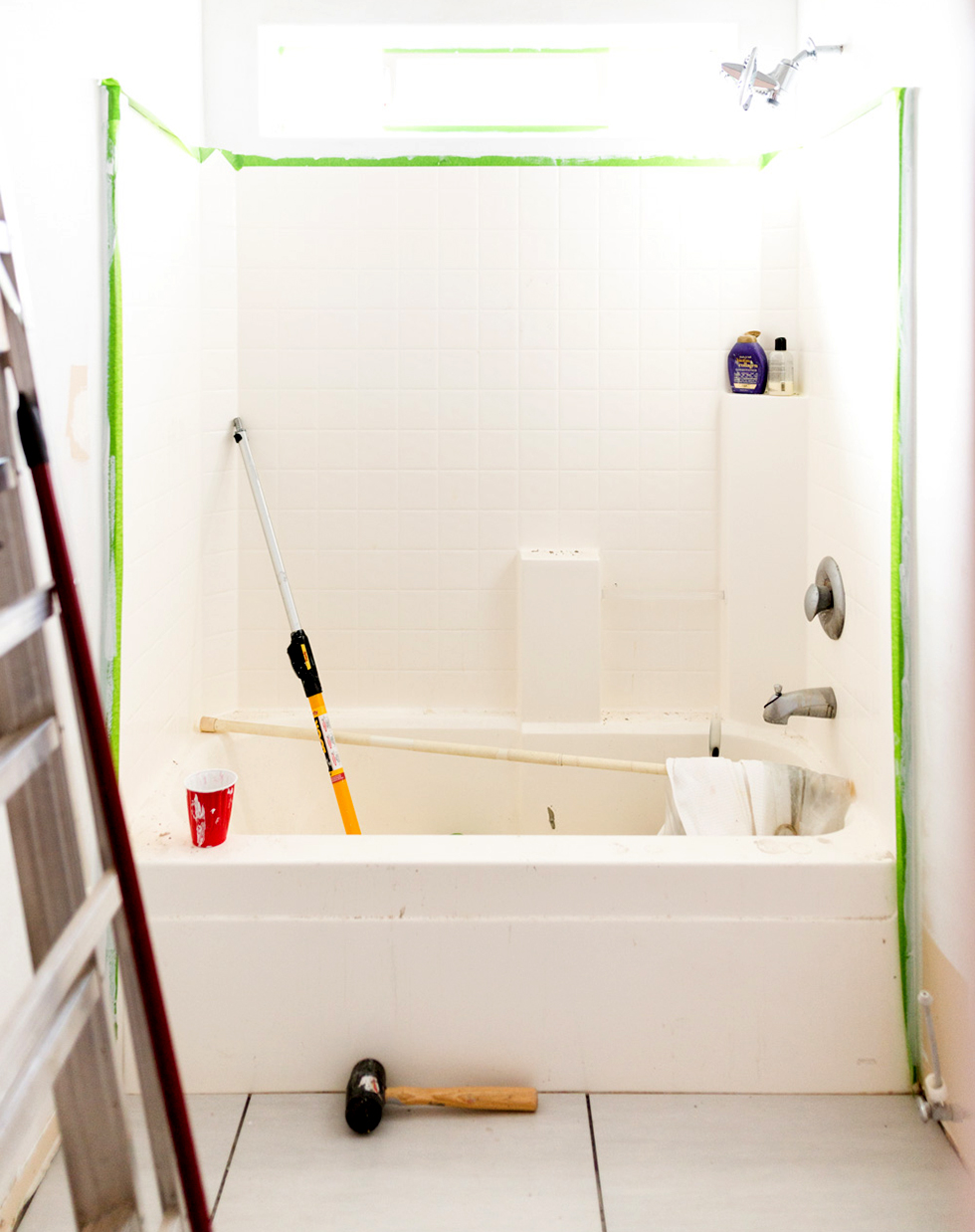 An all-white bathroom taped off for painting