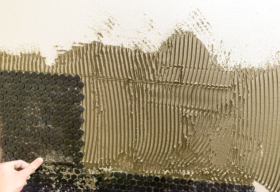 Thin set mortar being applied to a bathroom wall for tiling