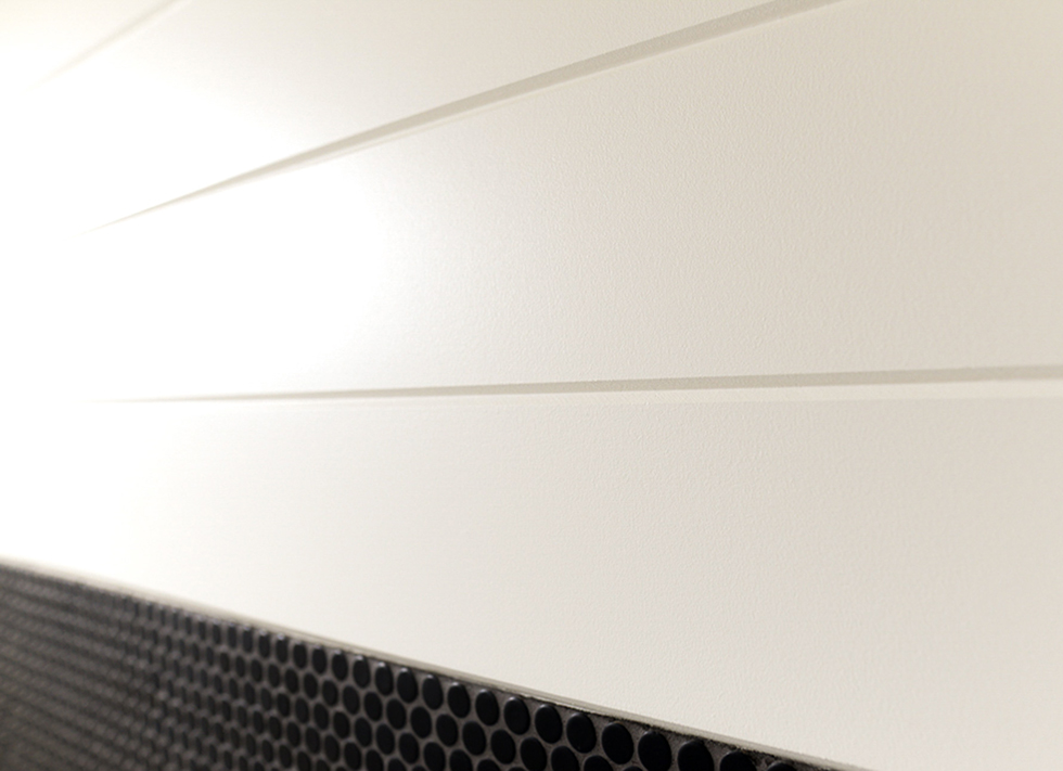Close up of white v-groove shiplap against black tile