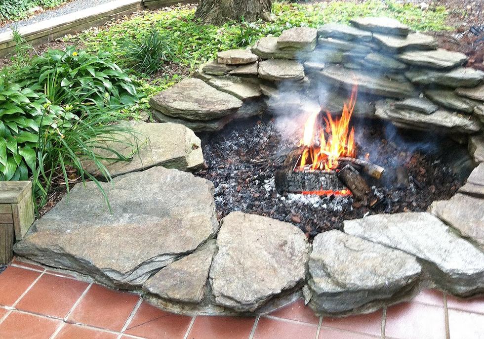 A koi pond converted into a backyard fire pit