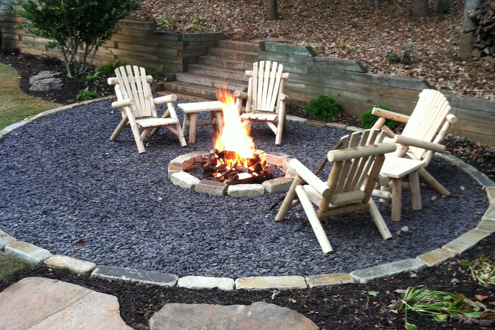 A gravel patio with fire pit, flagstone path, comfy chairs