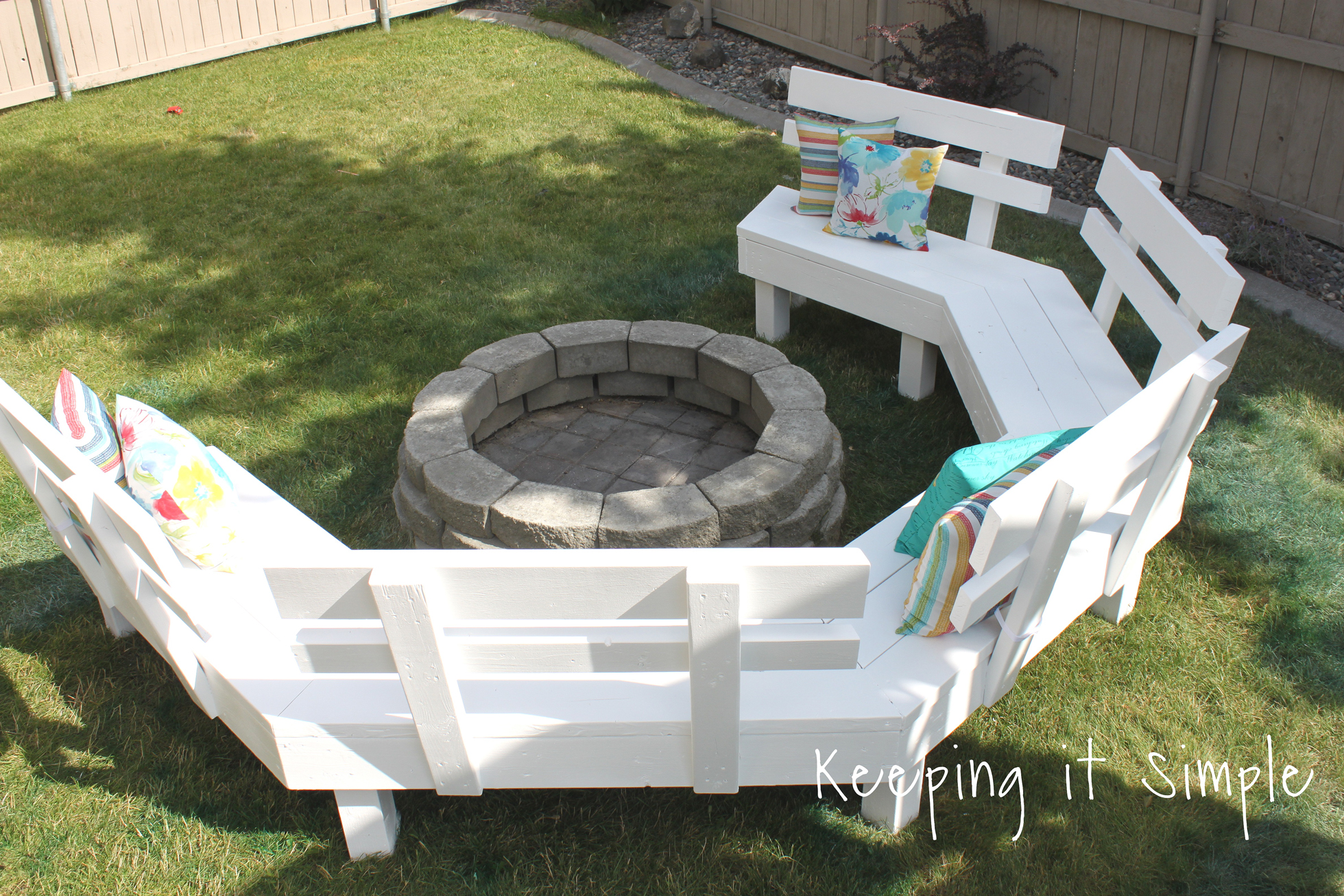 A white sofa bench surrounding a DIY paver fire pit