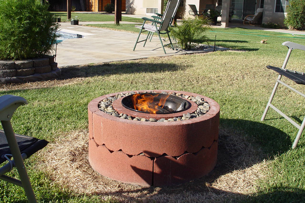 A clay-colored tree ring fire pit with flame