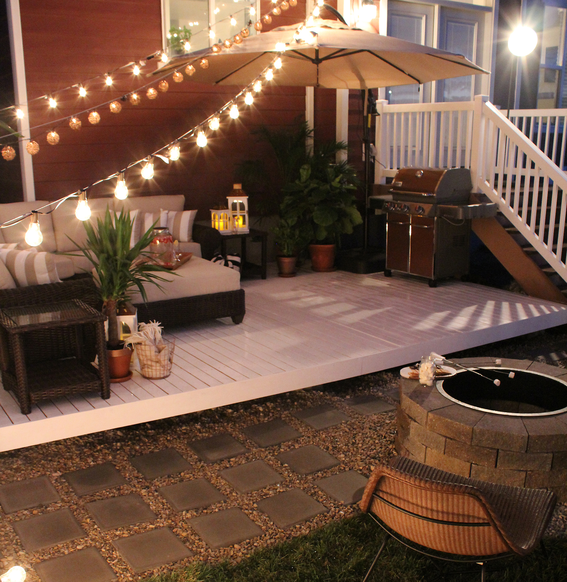 A light-colored deck with patio furniture at night