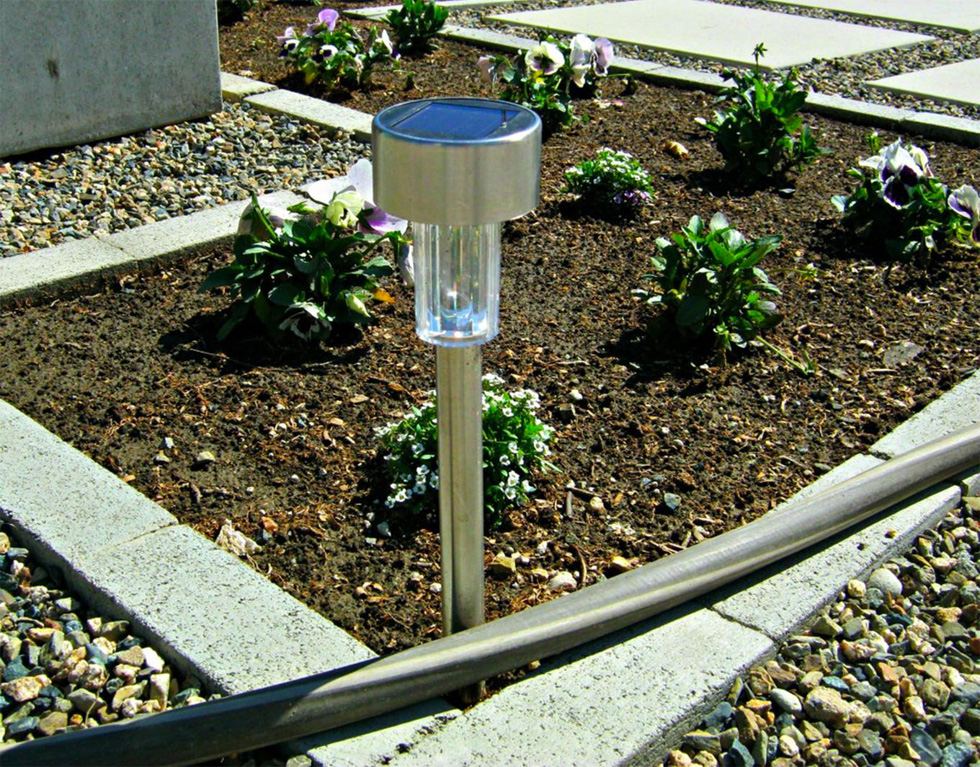 A solar light stands in dirt