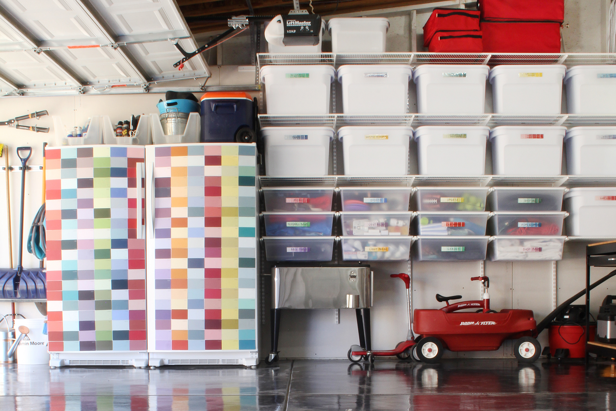 Clear bins with colorful labels on shelving in garage