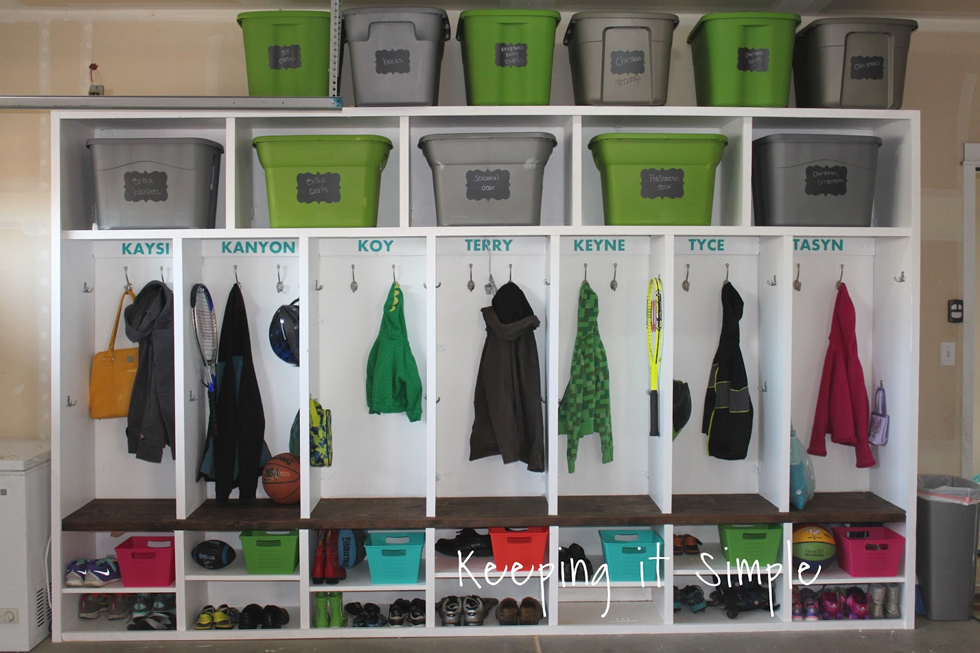 A white shelving unit in a garage with color storage bins