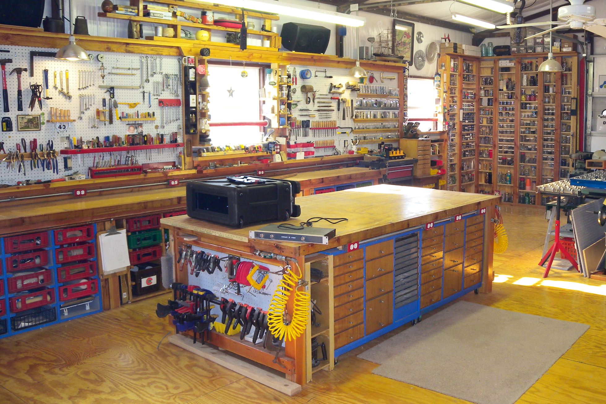 A large garage with multiple workbenches and a pegboard