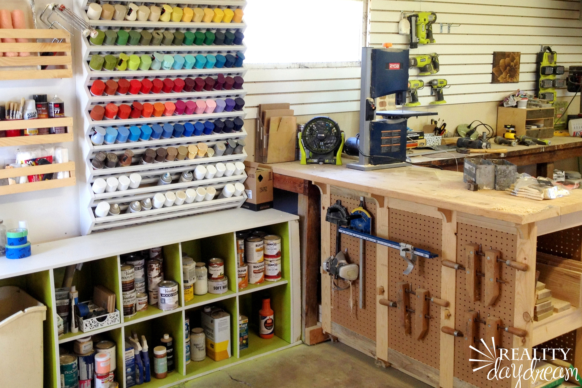 A garage with wood workbench and spray paint storage