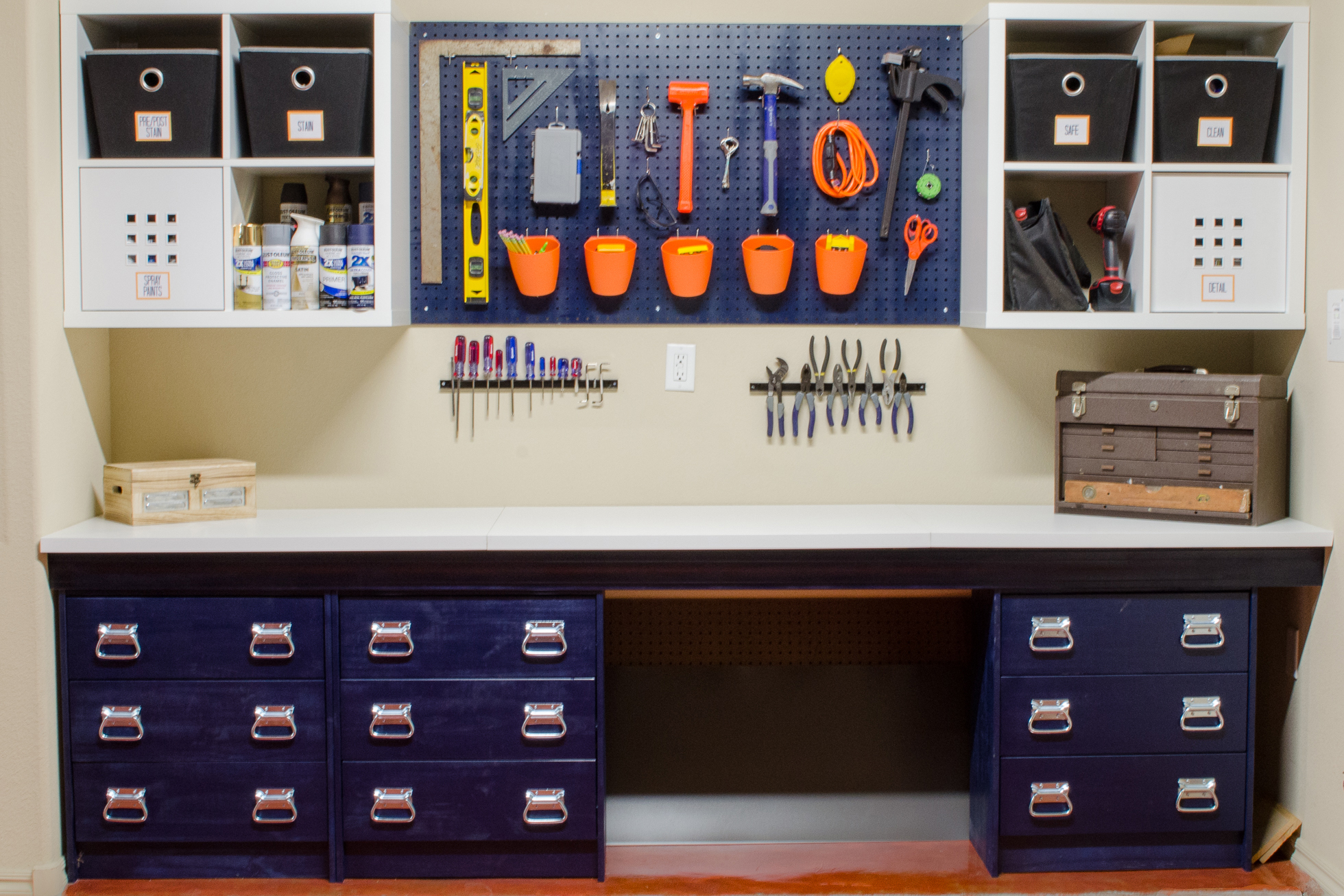 A blue workbench in a garage with a blue pegboard