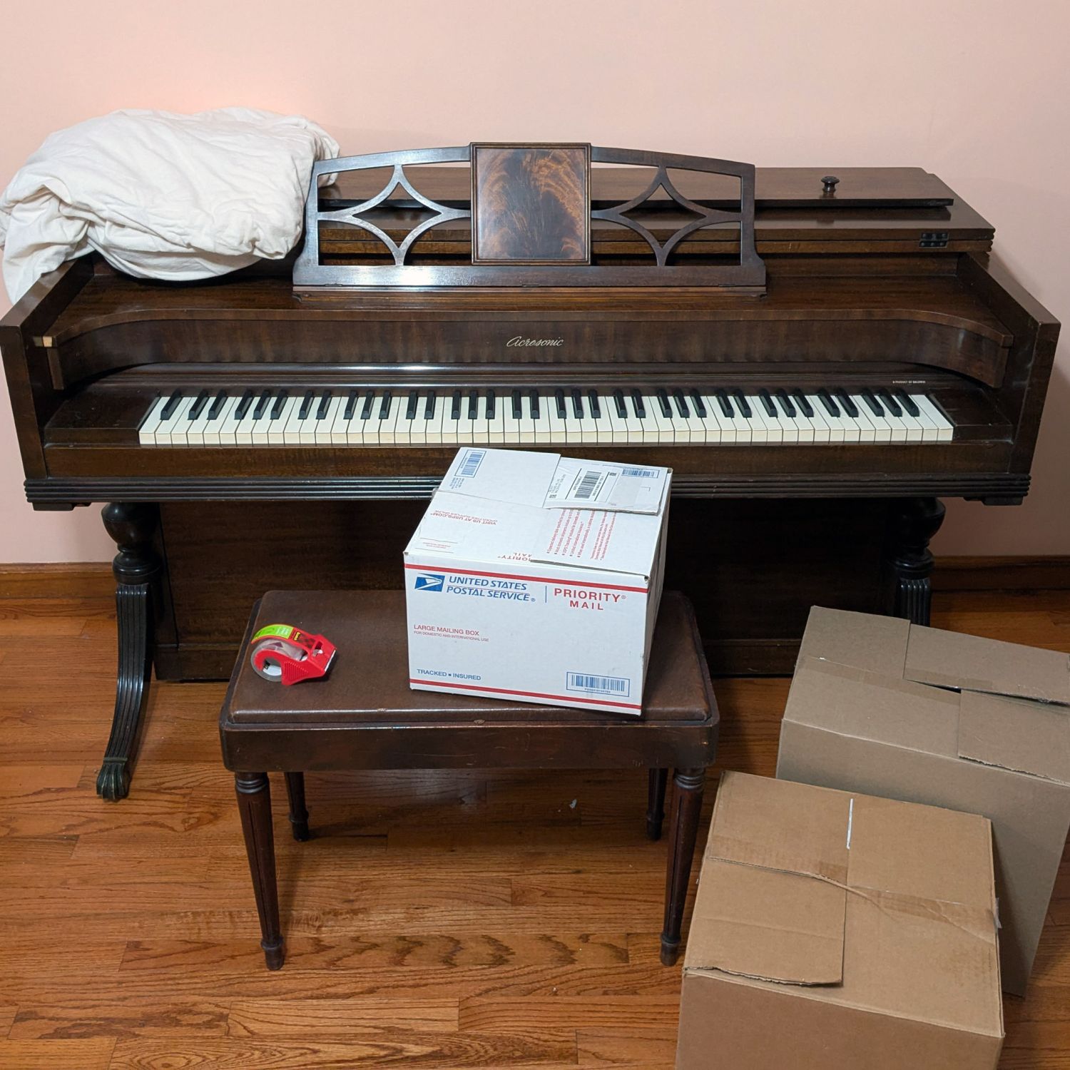 A piano surrounded by boxes; an example of a hard-to-discard item when decluttering or moving.