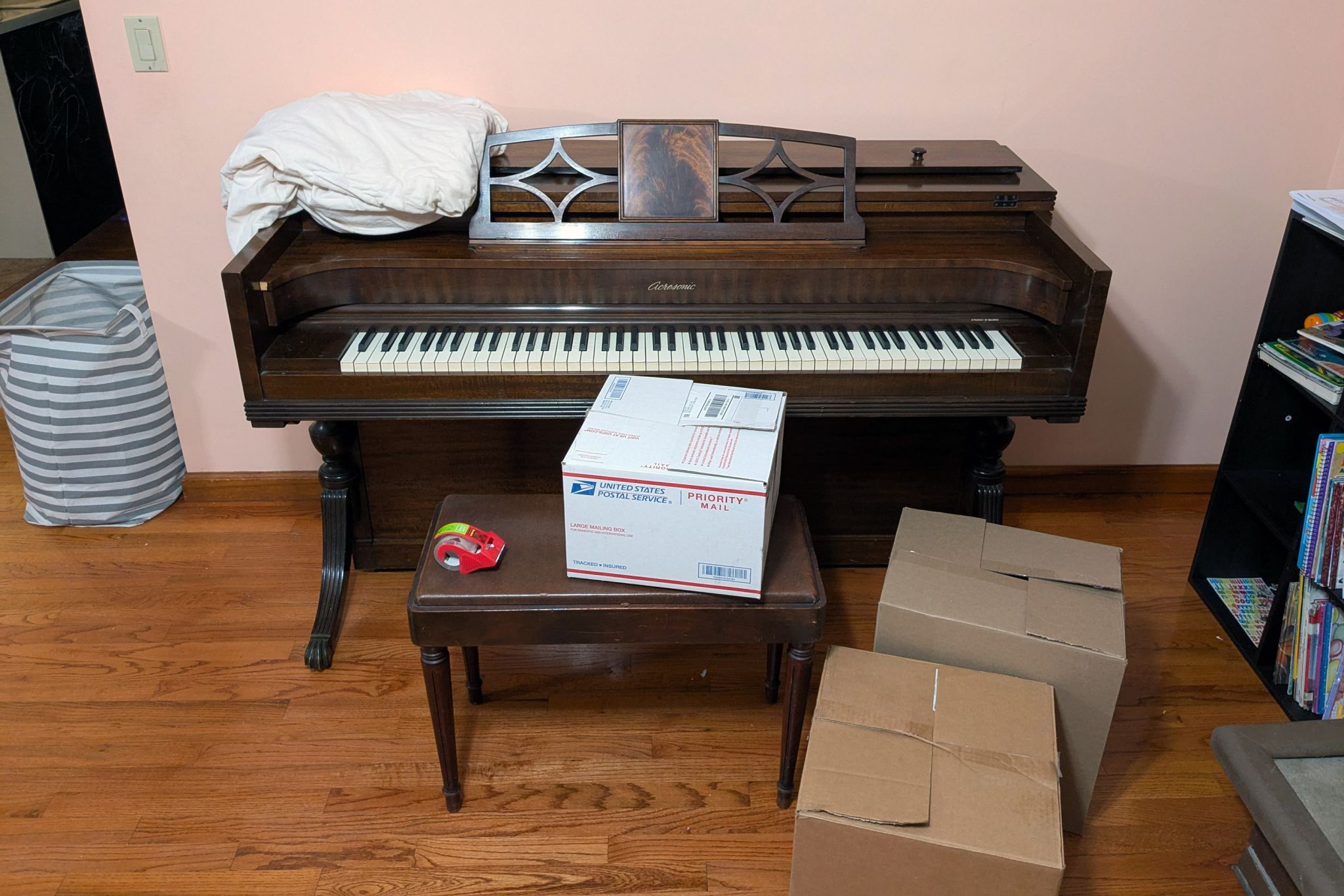A piano surrounded by boxes; an example of a hard-to-discard item when decluttering or moving.