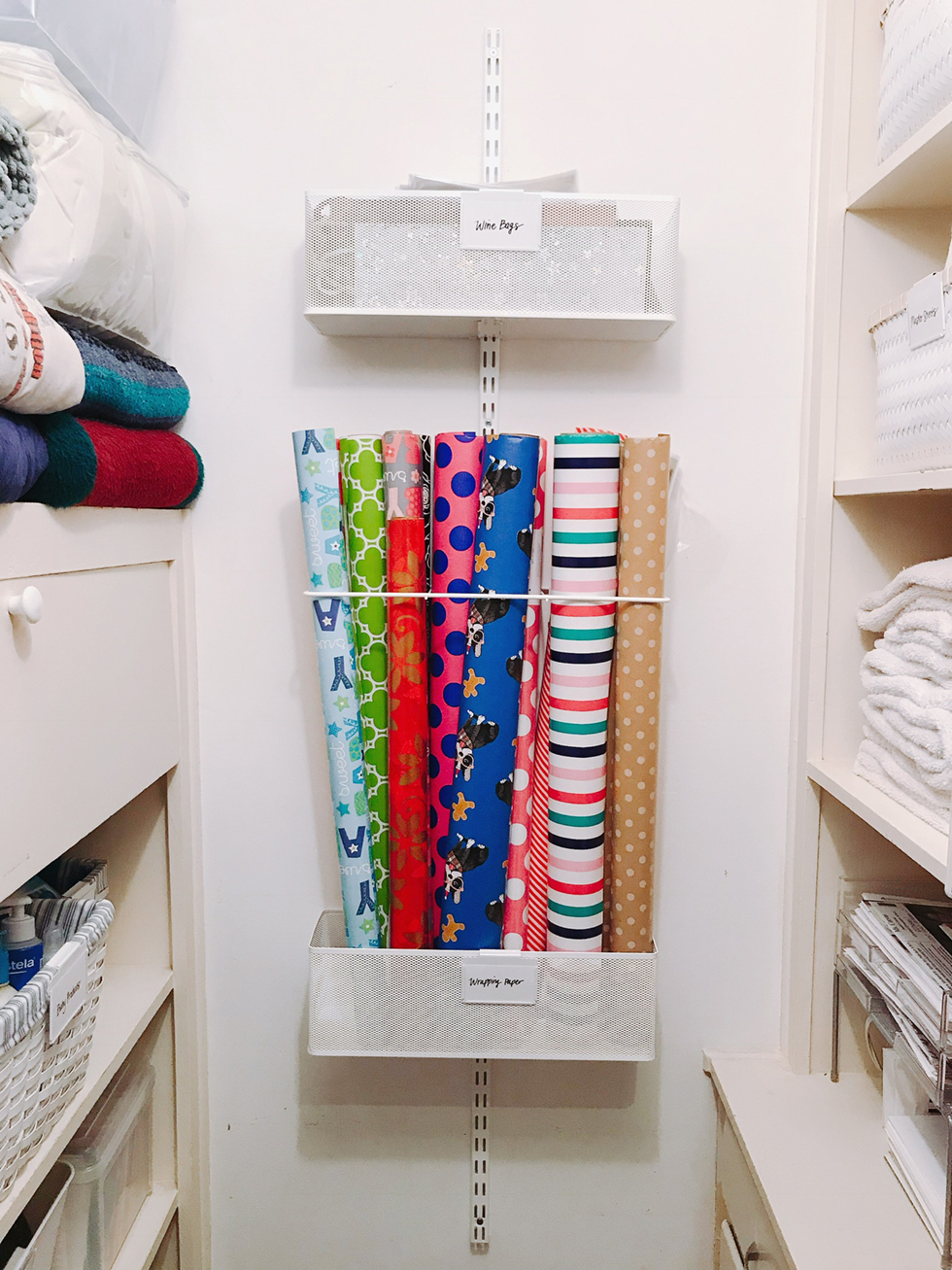 Wrapping paper tubes corralled against a wall in a closet