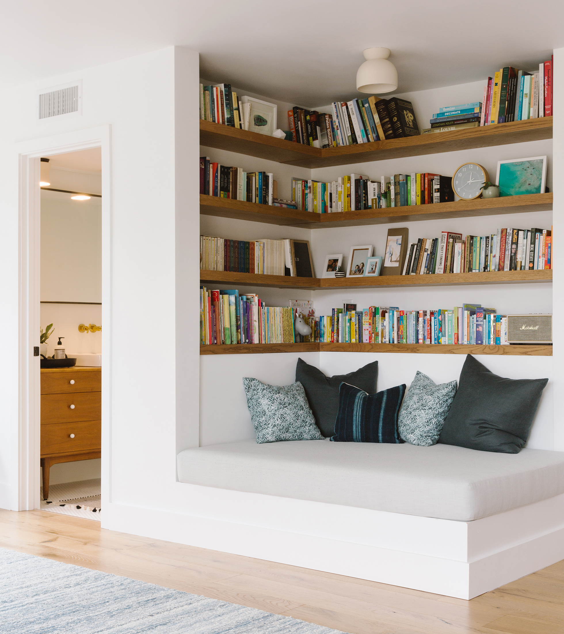 White built-in bookshelves with cushioned bench at bottom