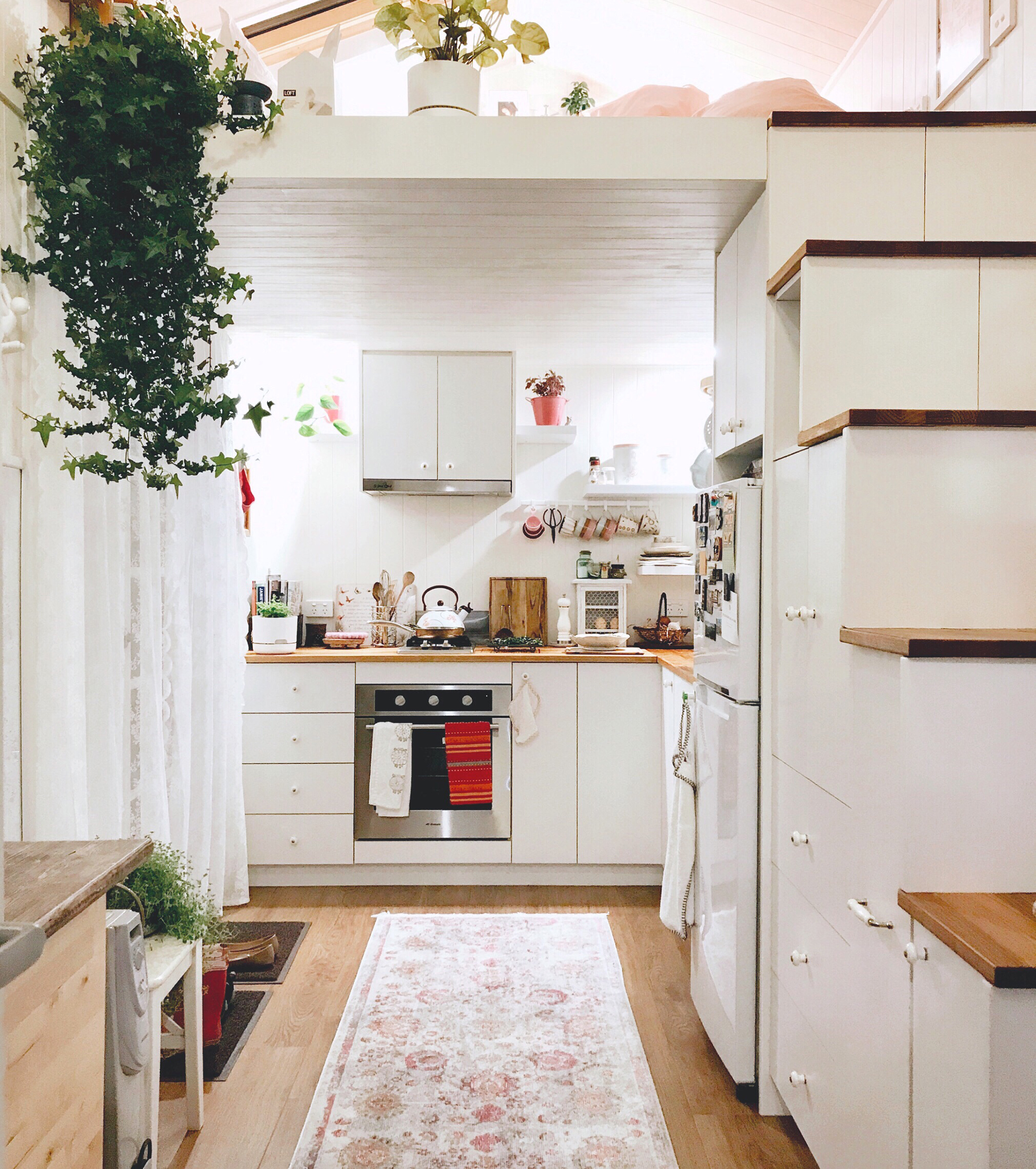 White steps with built-in storage leading to loft bedroom