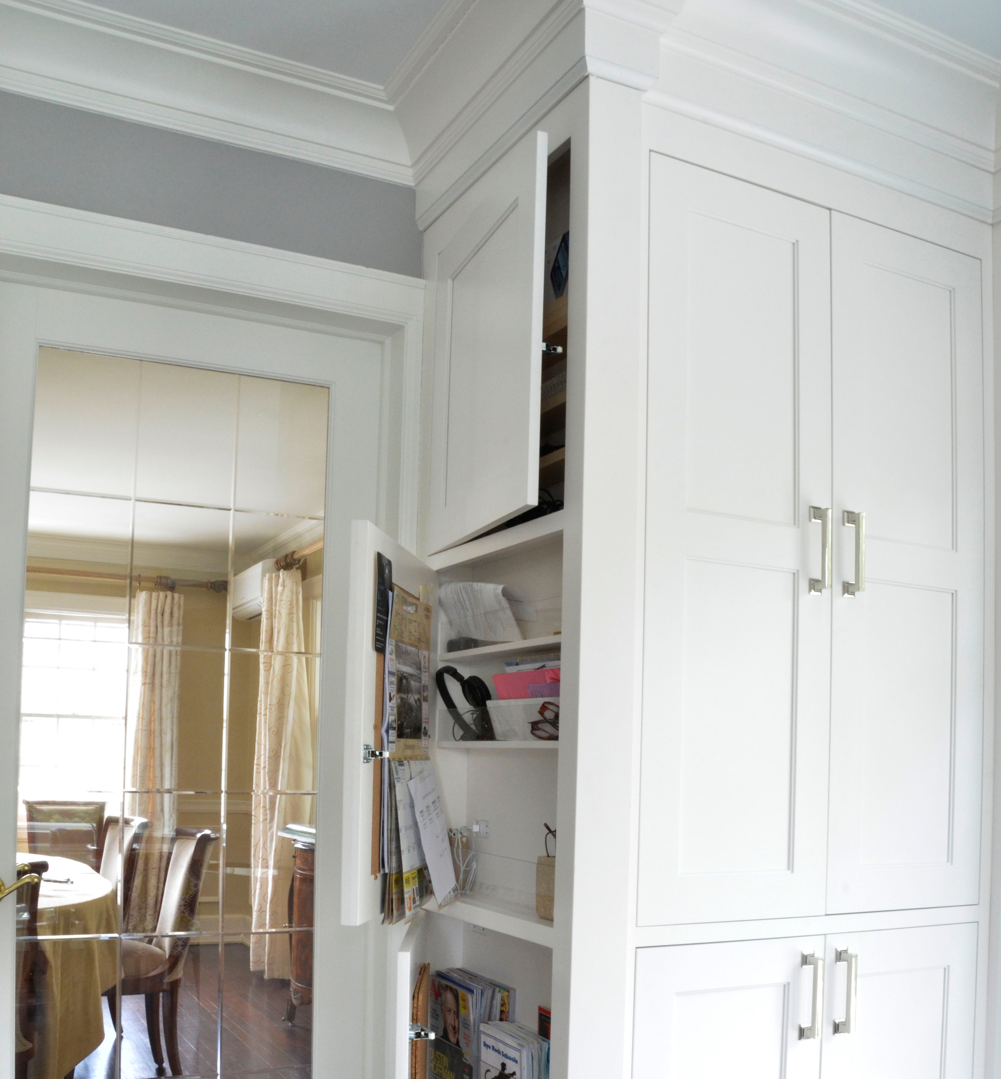 White cabinets conceal storage in a kitchen