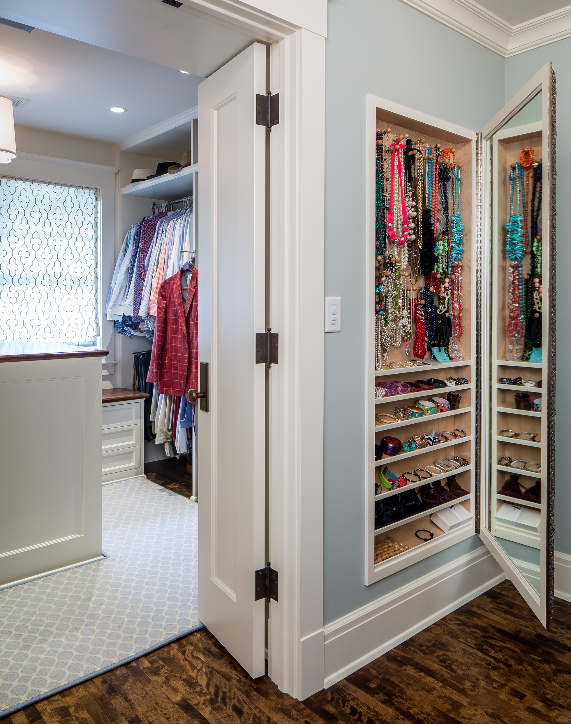 A wall mirror opens to reveal jewelry storage system