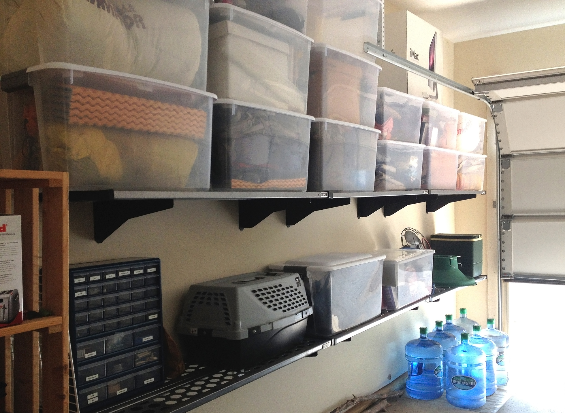 Plastic tubs on a wall organizer in a garage