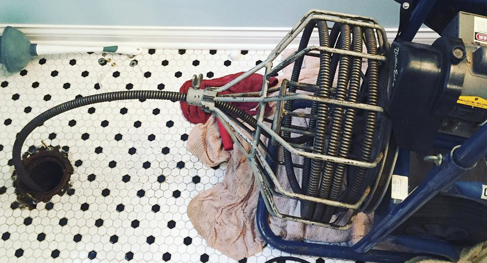 Plumber's snake being used in a home bathroom