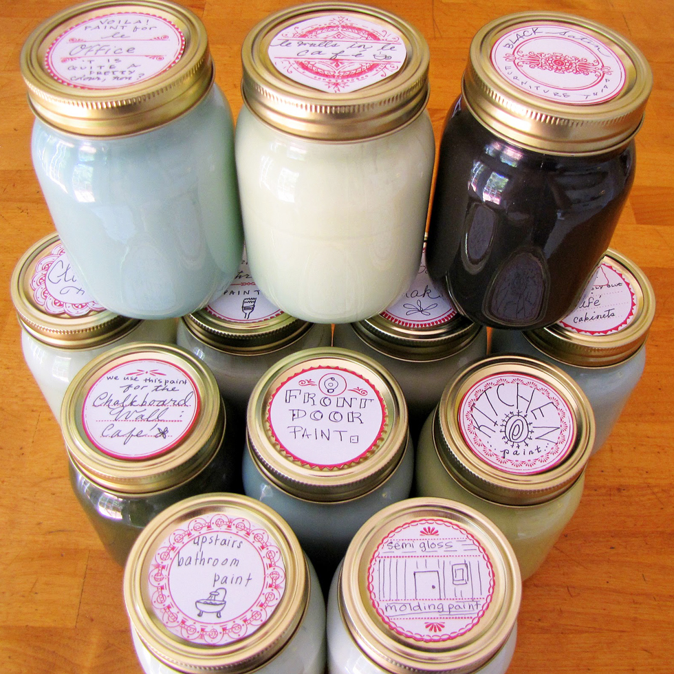 Stacks of mason jars filled with paint on a wood floor
