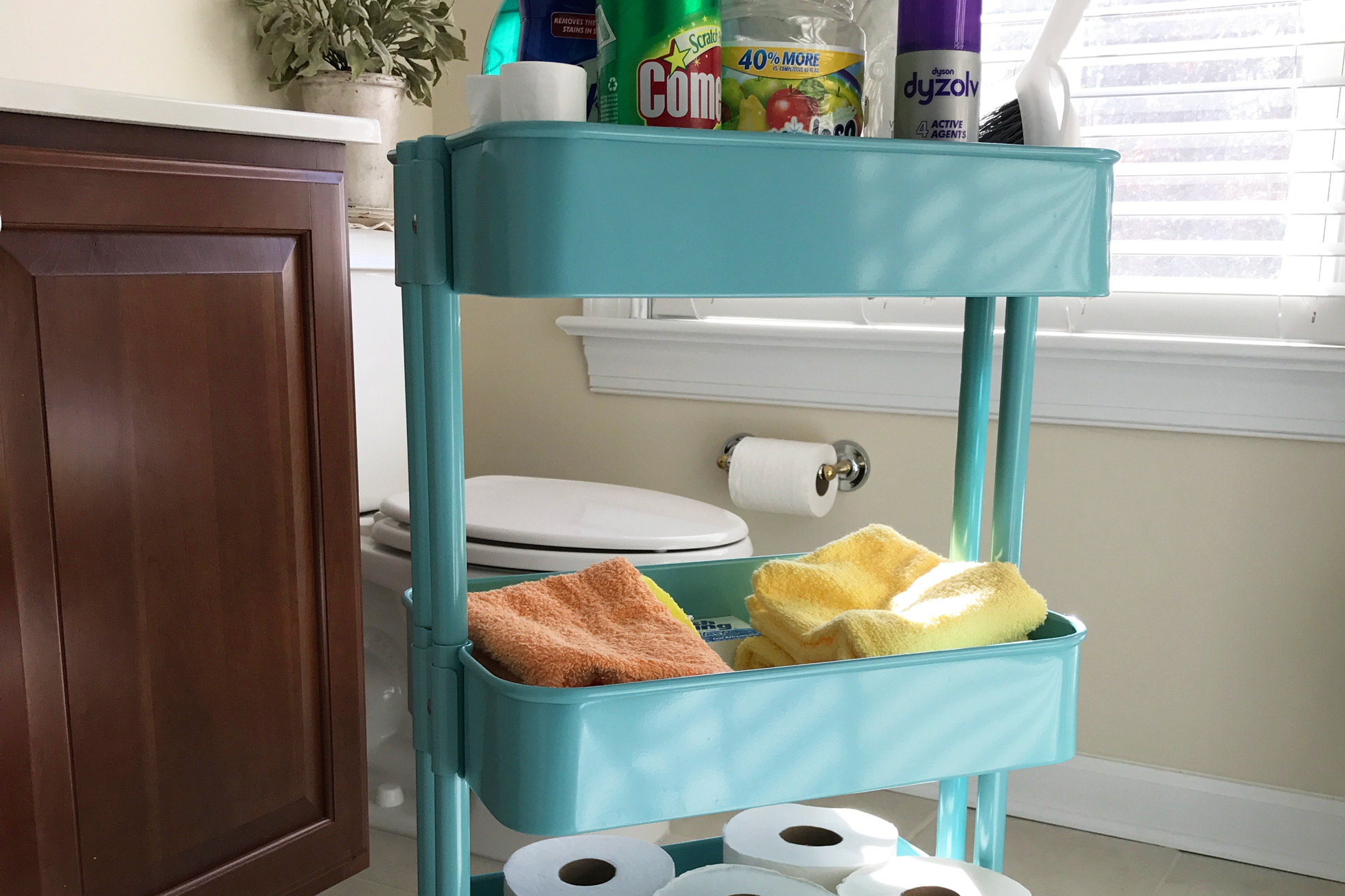 Blue cart with cleaning supplies in a bathroom