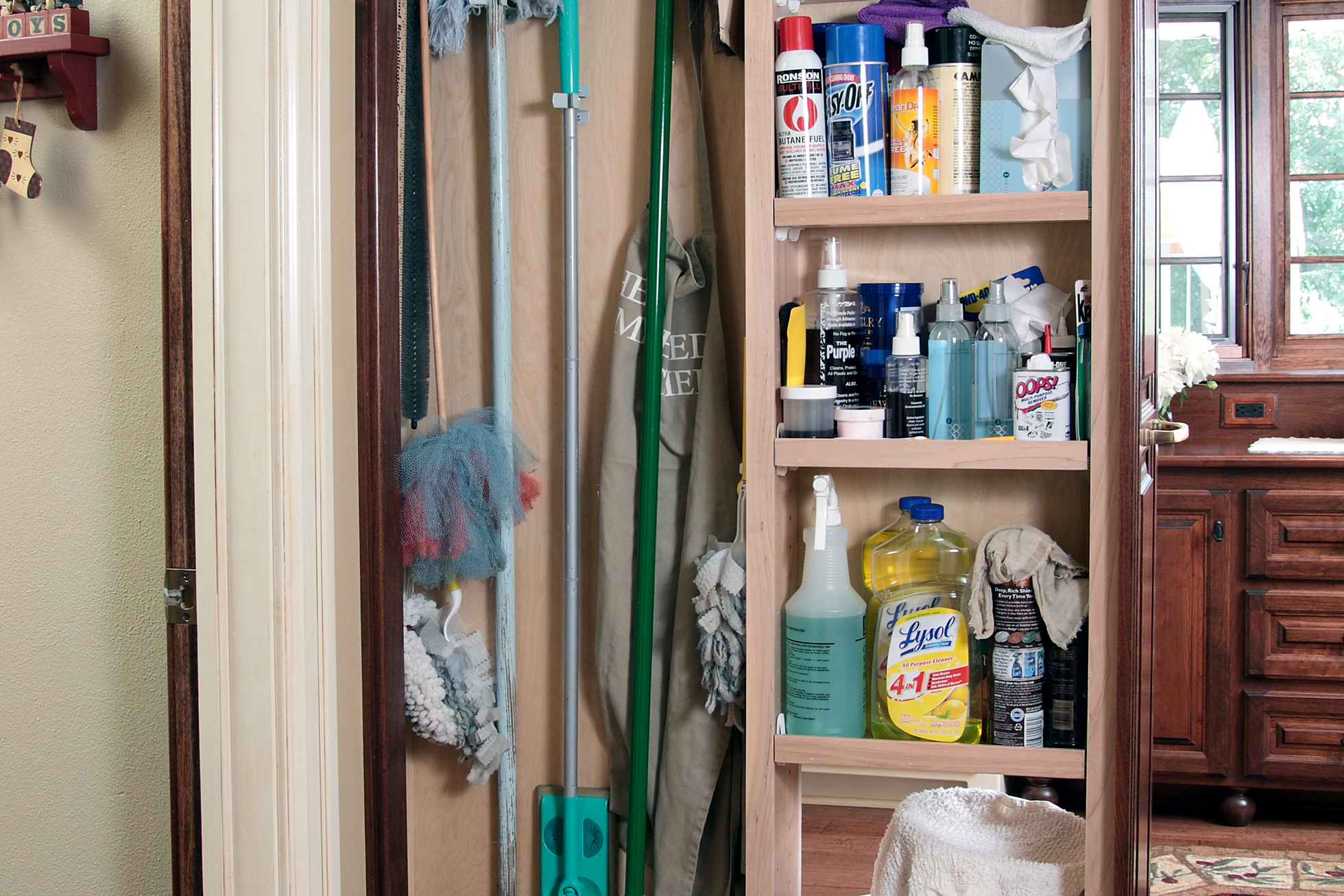 A pull-out cabinet filled with cleaning supplies in kitchen