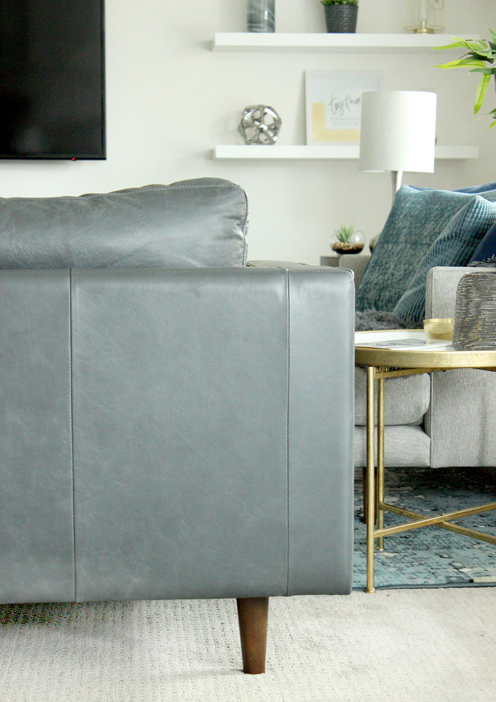 Back of gray couch in living room decorated with cool colors