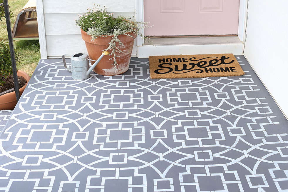 Gray and white stenciled front porch with welcome mat