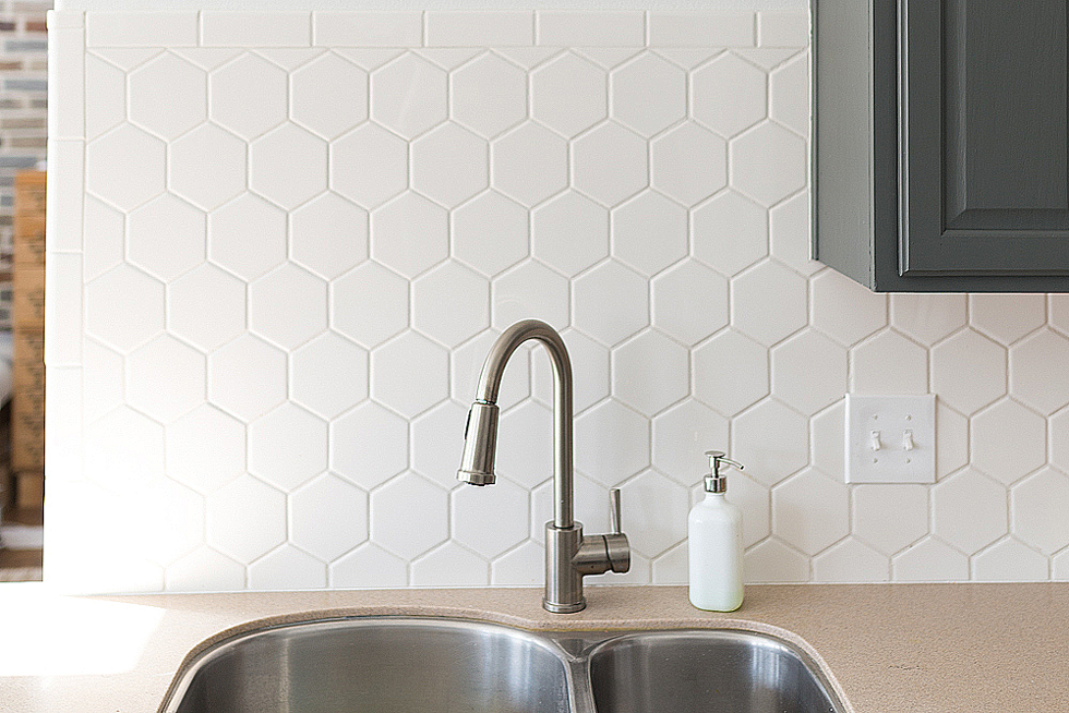 White tile backsplash above a kitchen sink