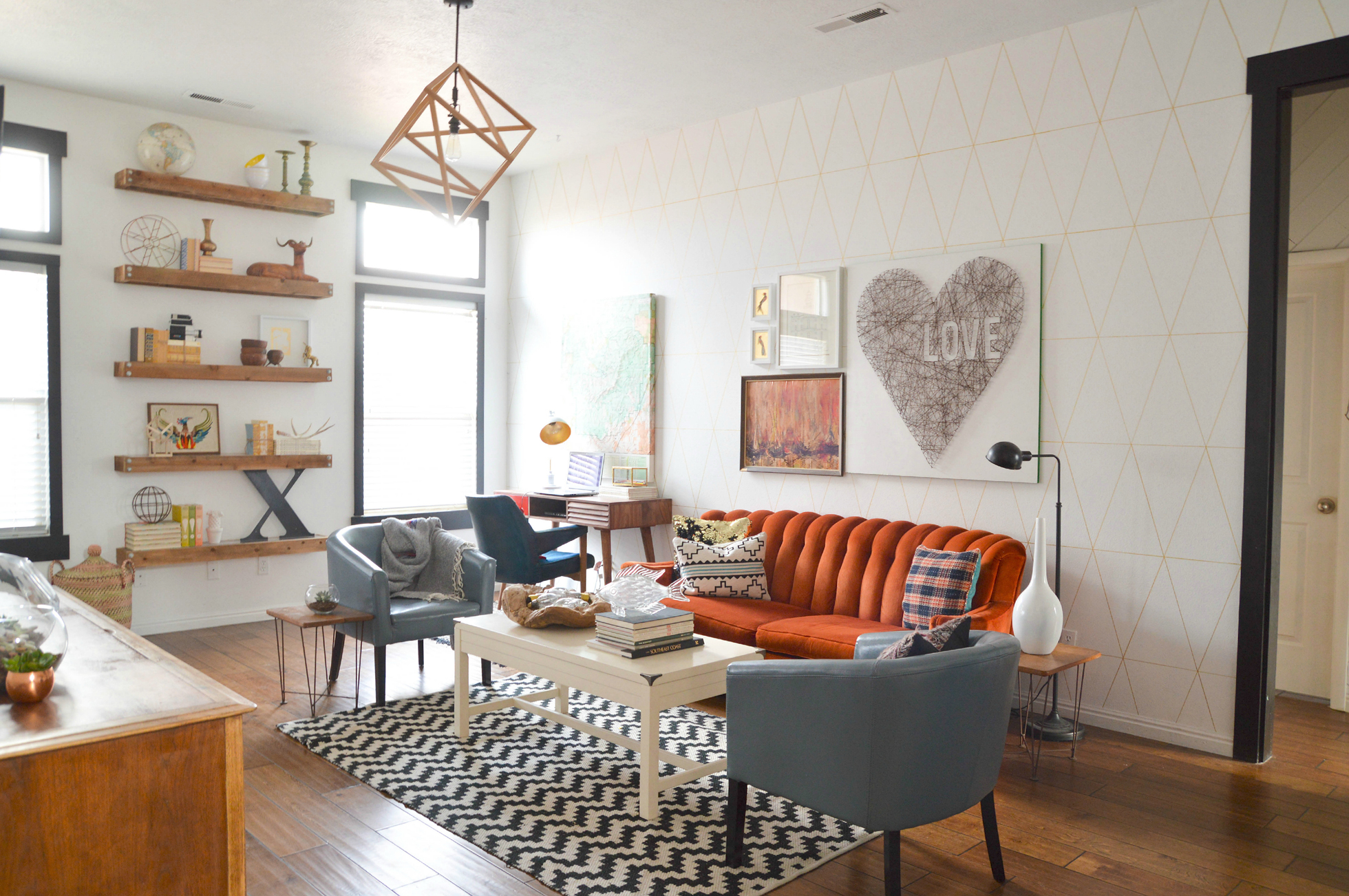 White living room with drawn-on wallpaper and wood floors