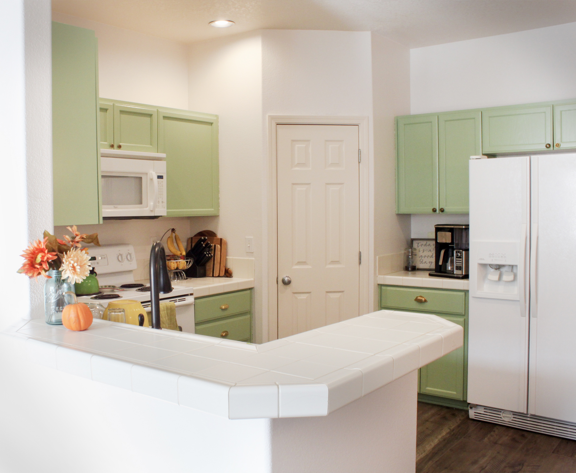 Kitchen cabinets painted in a light pistachio green