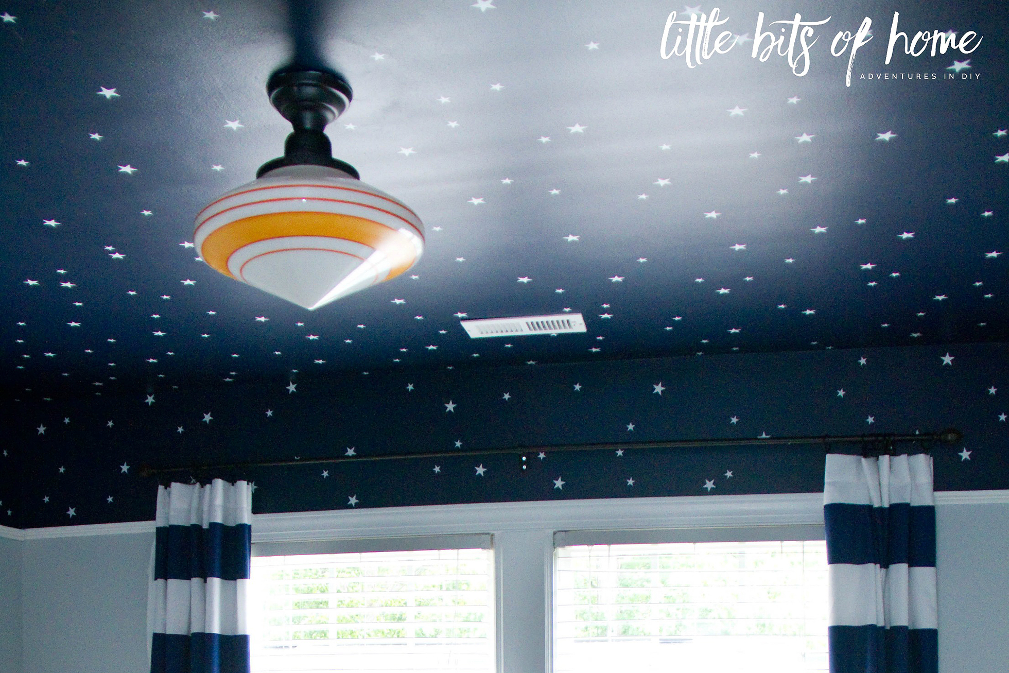 A dark blue ceiling with white stars and BB-8 light fixture