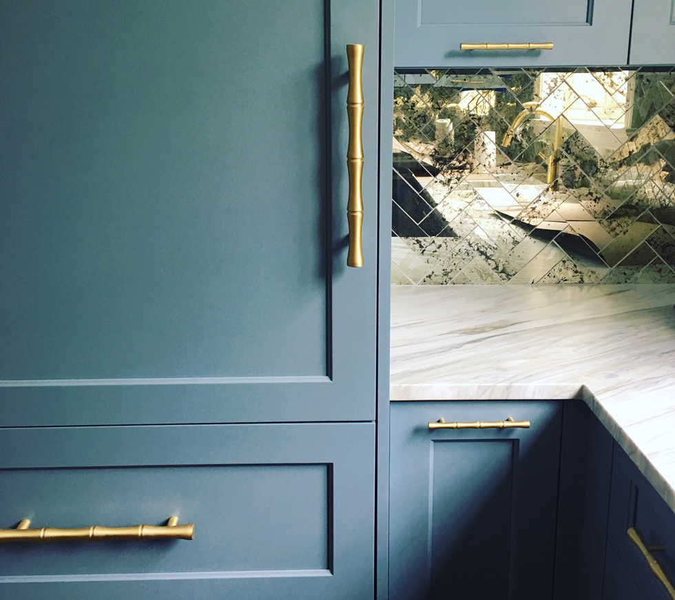 Blue gray kitchen cabinets with gold bamboo-style pulls