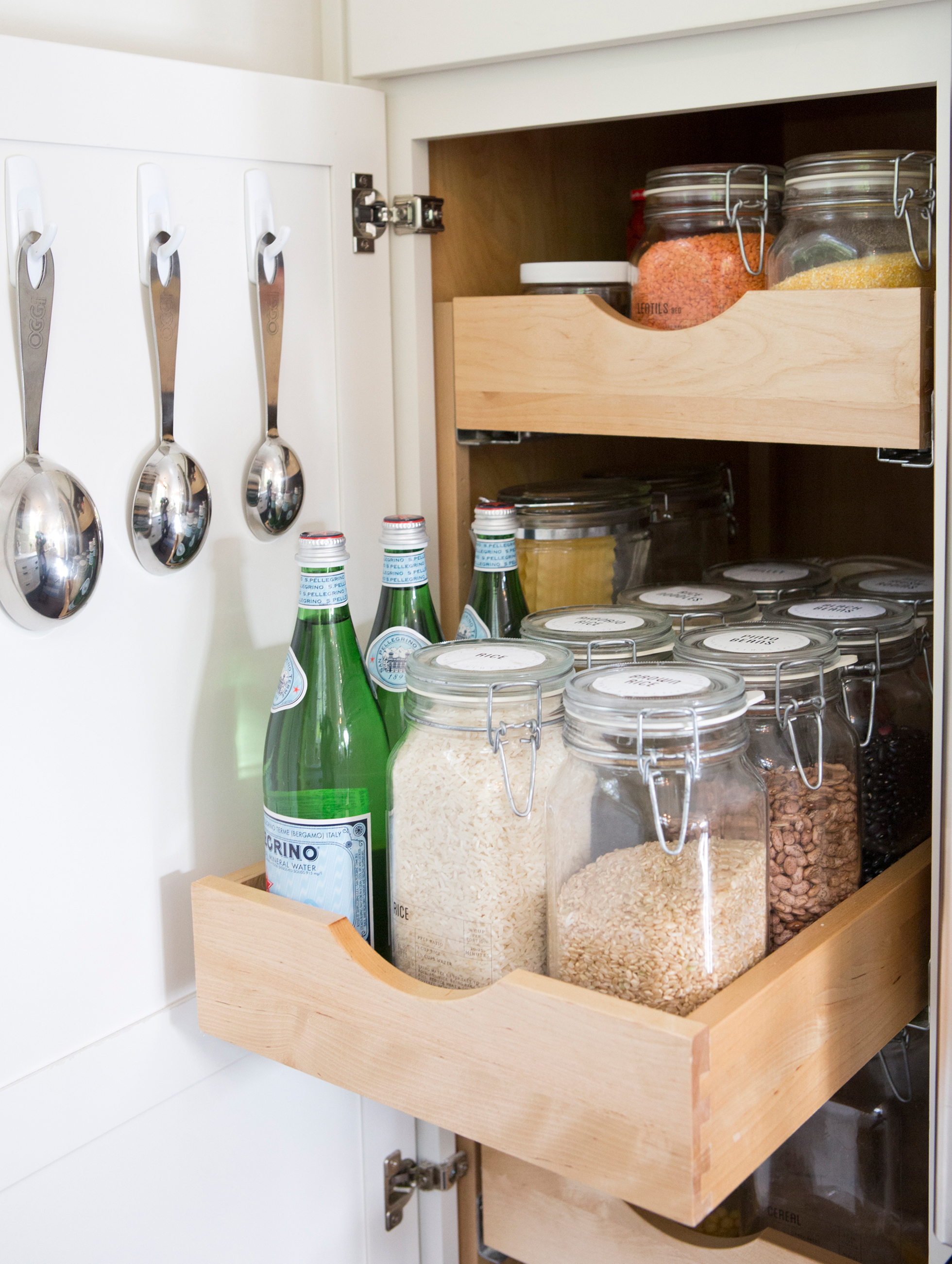 Clear jars in a pull-out drawer in a kitchen cabinet